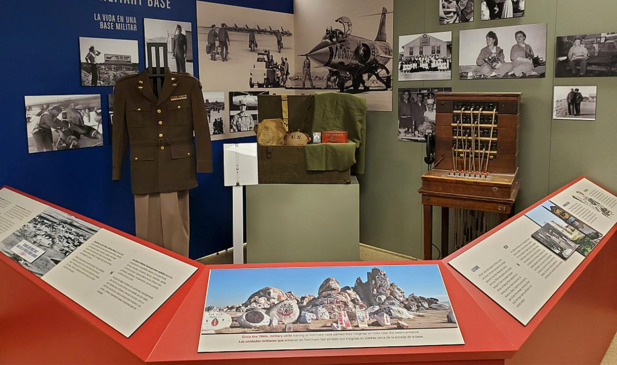 A WWII military exhibit with uniforms, photos and equipment including personal gear.
