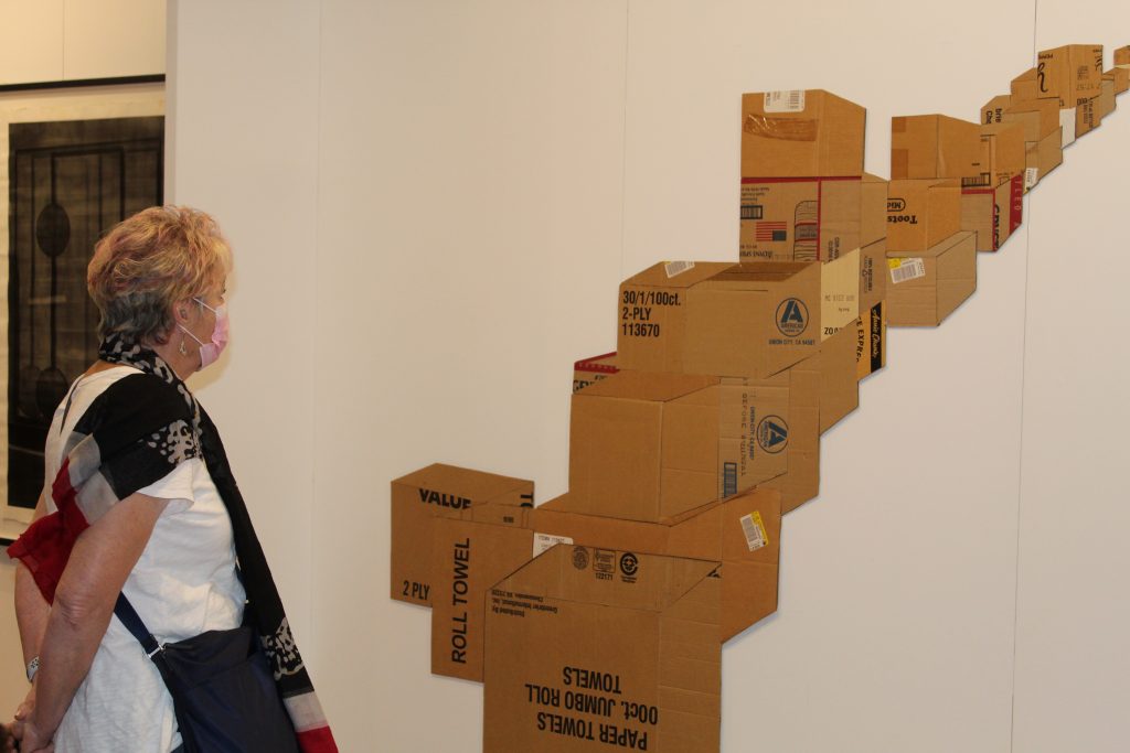 Woman observes cardboard art
