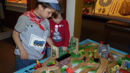 Two kids looking at train setup