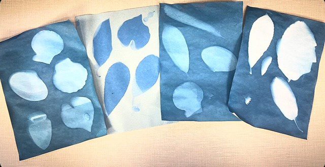 Four sheets of paper featuring blue and white leaf designs scattered across them.
