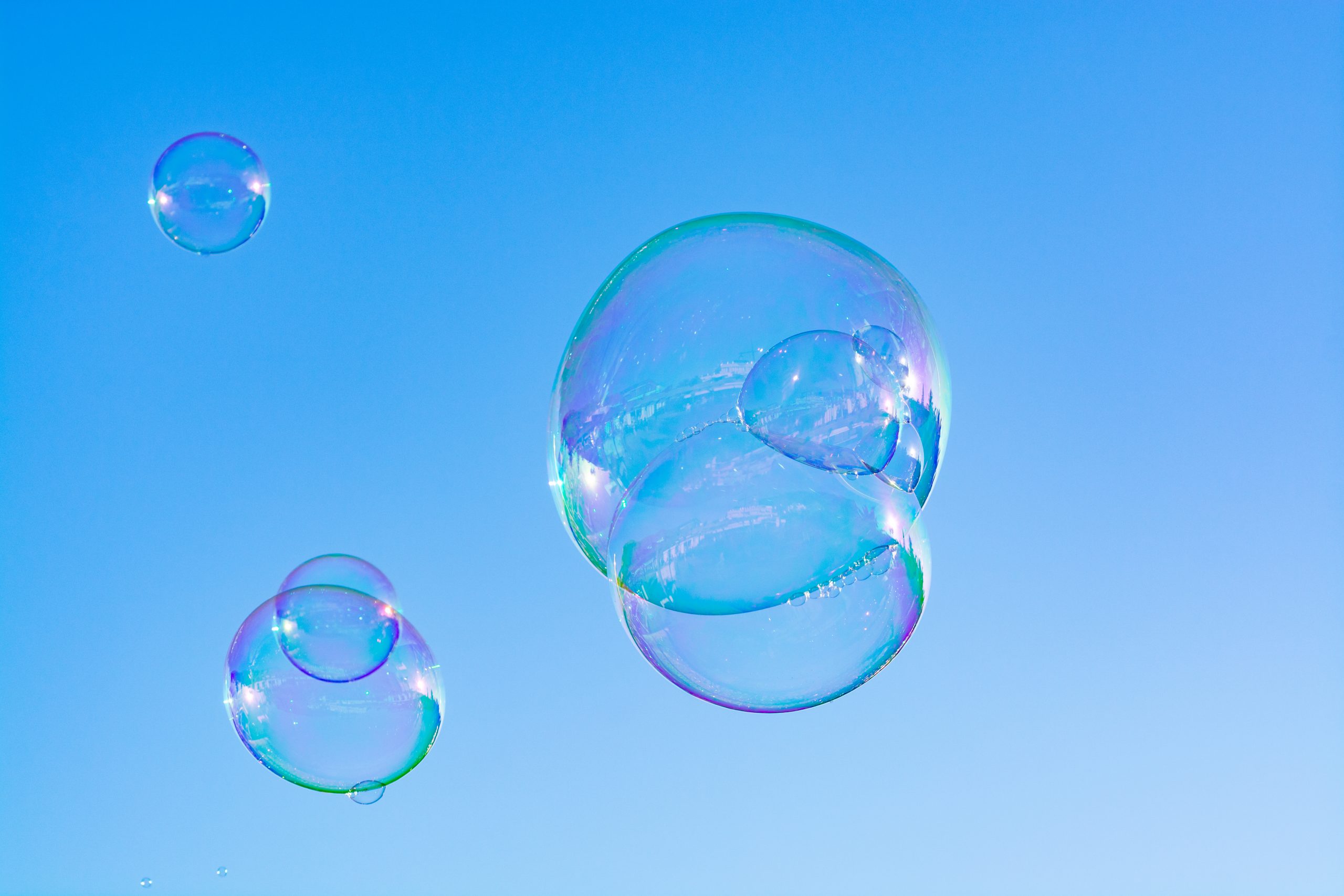 Many soap bubbles in air, blue sky, outdoor fun for everybody.
