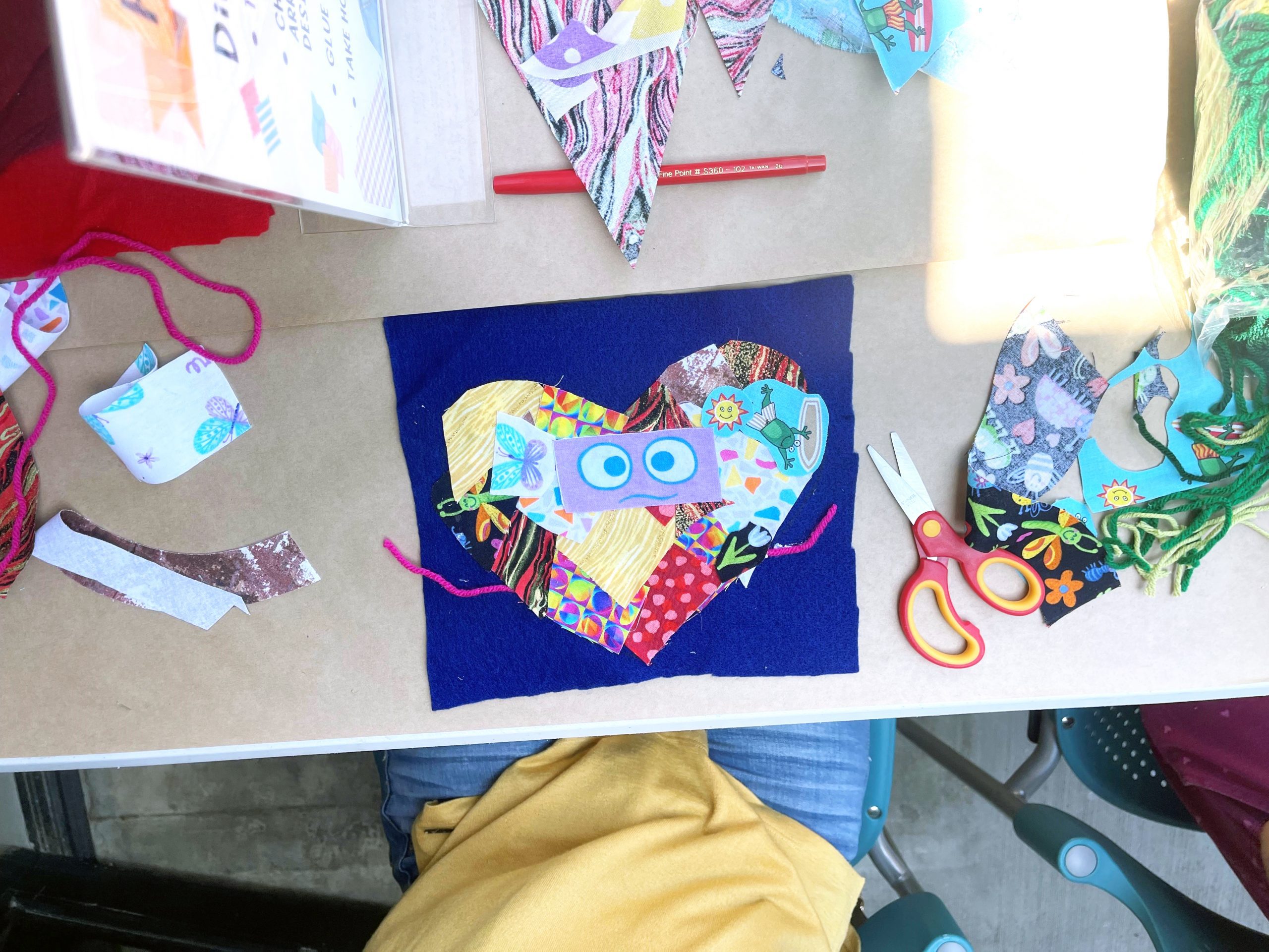 A young museum visitor is participating in STEAM Saturday Cloth Collage art project.